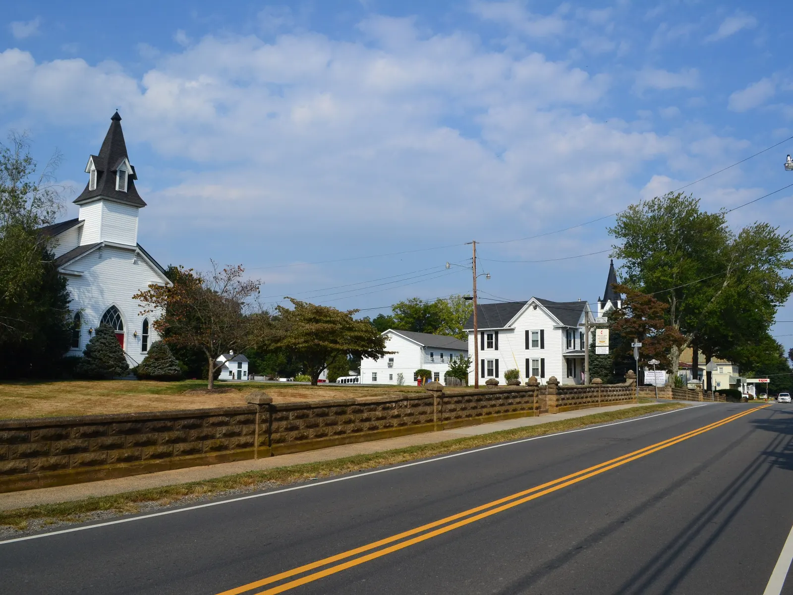 A white church and houses along the main road in Round Hill